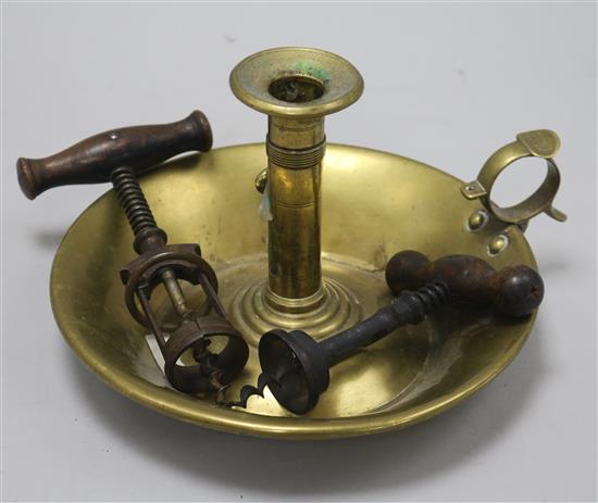 A brass candle holder and two various cork screws